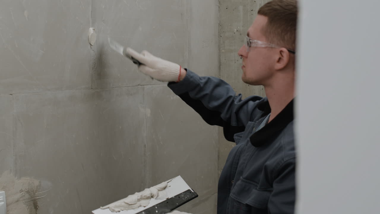 Construction Worker Applying Grout to Wall Tiles
