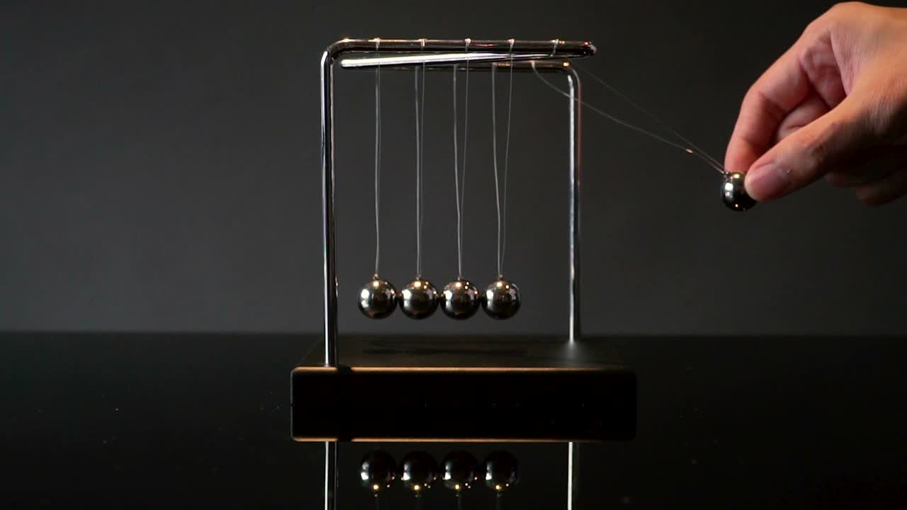 뉴턴 크레들 (newton cradle) 의 손으로 끌어당기는 공