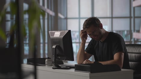 man sit indoor closed eyes rub temples suffering from headache. stressed young man in glasses suffering from muscles tension having painful head feelings due to computer overwork or sedentary working