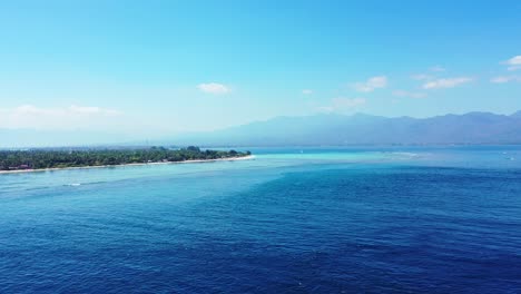 a beautiful scenery in indonesia with glorious trees and blue calm ocean - aerial shot