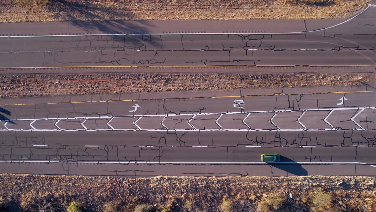 vista aérea de arriba hacia abajo, tráfico en la carretera del desierto americano, ruta estatal con vehículos y asfalto agrietado, disparo de drone de alto ángulo
