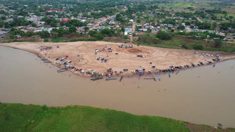 the beach by the river in elorza, with people and boats on the shore, aerial view