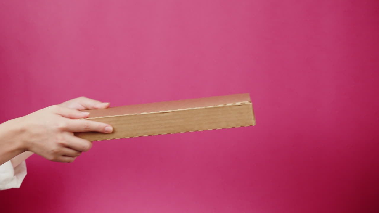 Hands Giving and Receiving a Small Cardboard Box