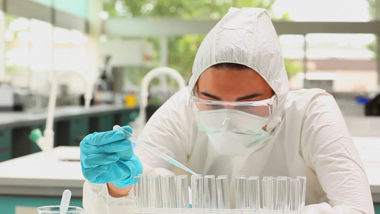 Scientist pouring blue liquid in test tubes