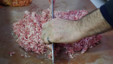 a man chopping ground meat for a recipe