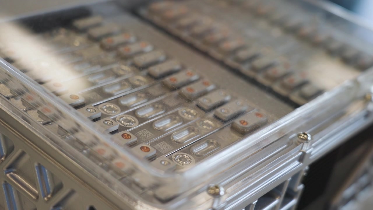 Primo piano di celle di batteria per veicoli elettrici disposte in un modulo metallico in Cina, che evidenzia la tecnologia avanzata di accumulo energetico e la moderna produzione di mobilità elettrica, UHD