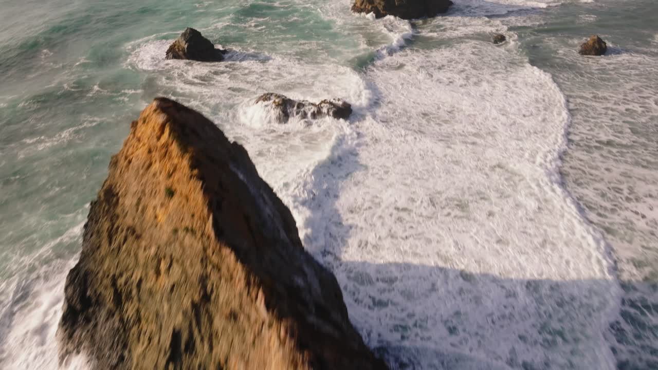 Aerial view of waves crashing on California coast, peaceful ocean scene