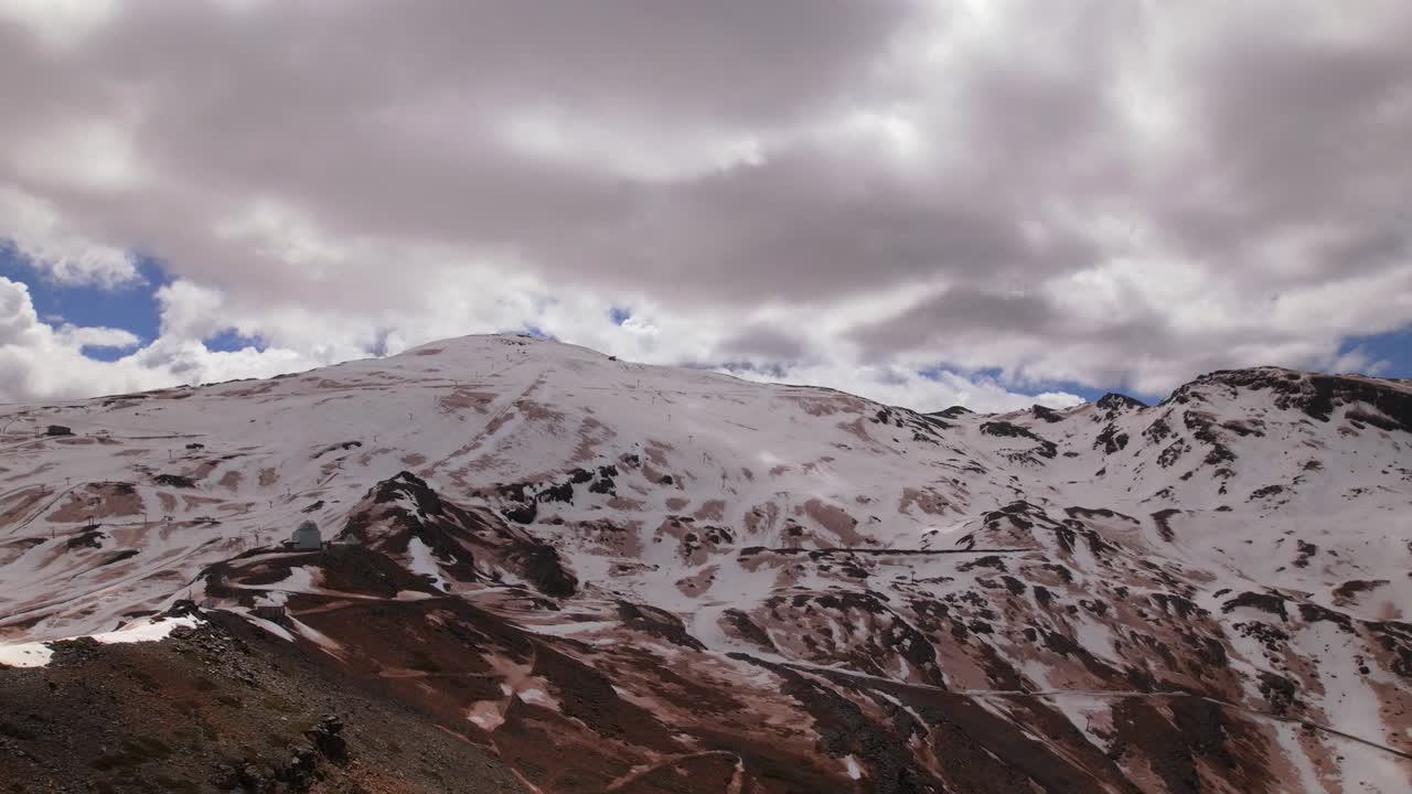 montañas nevadas y nubes que pasan a gran velocidad a través del cielo