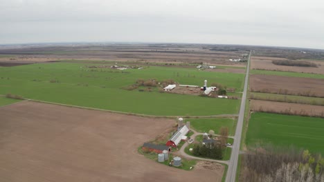 Scheunen-Und-Silos-Von-Bauernhöfen-Und-Flecken-Von-Grünem-Und-Braunem-Land-Durchziehen-Die-Landschaft