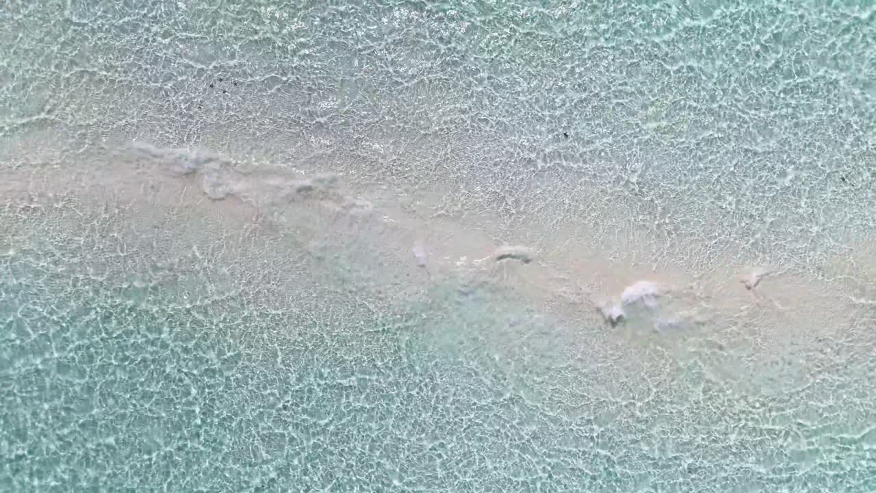 Crystal-clear waters ripple over the pale stretch of Candaraman Sand Bar, a stunning remote shoal in Balabac, Palawan, Philippines seen from aboveCandaraman Sand Bar, Balabac, Palawan, Philippines