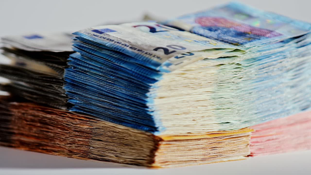 Slow motion rotating euro cash stack shows savings, pensions, and pressure