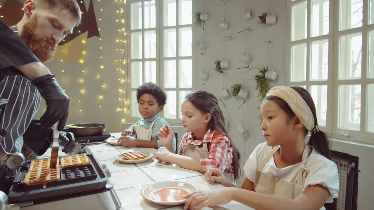 Chef che mette i waffle sui piatti per i bambini a una masterclass di cucina