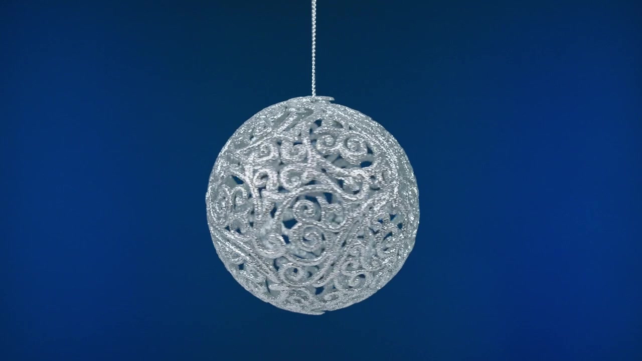 Funkelnde silberne Weihnachtskugel hängt auf blauem Hintergrund