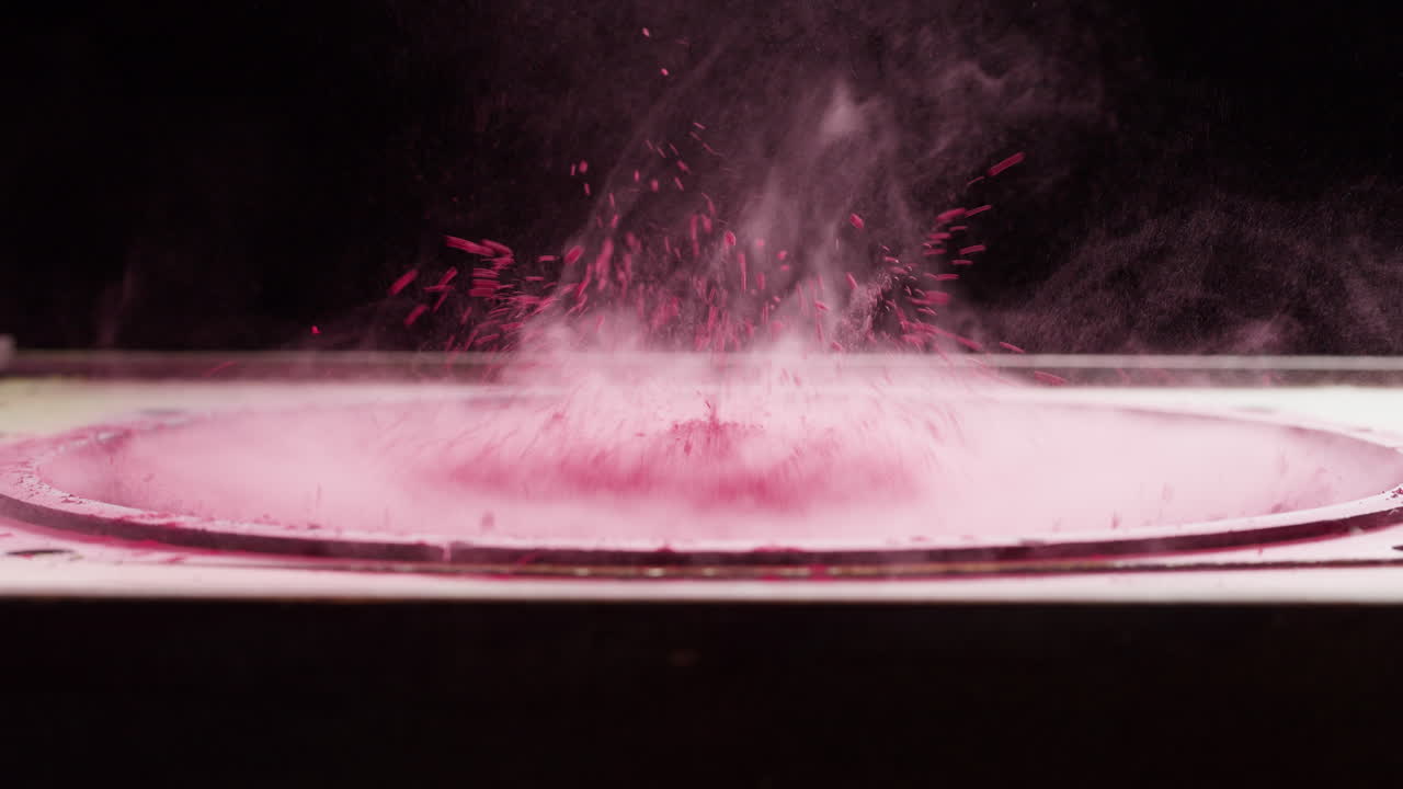 Pink pulver danser og eksploderer på en vibrerende højttaler
