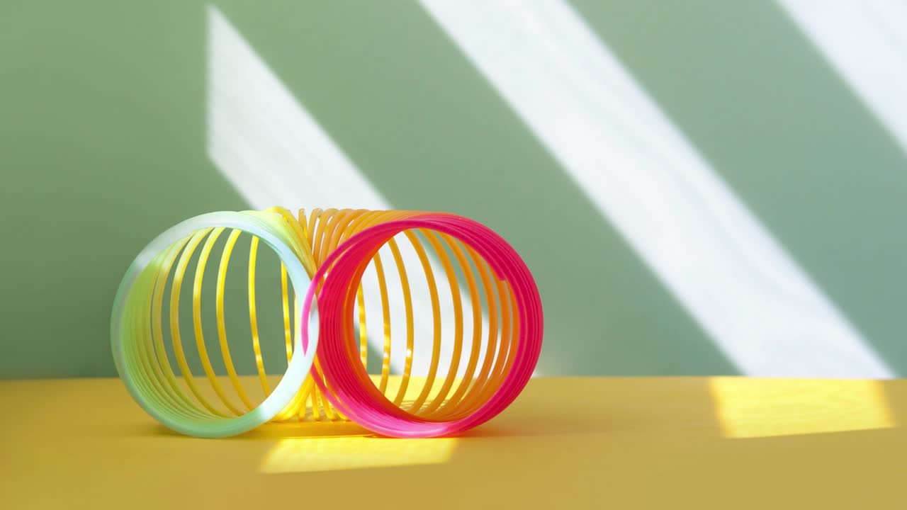Stop motion from toy plastic colorful rainbow spiral, antistress concept.