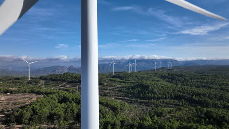 extreme close up on wind farm turbine with views over mountainous terrain