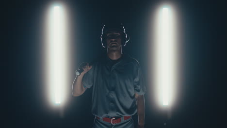 jugador de béisbol profesional caucásico posando contra un fondo oscuro. 4k uhd 60 fps cámara lenta