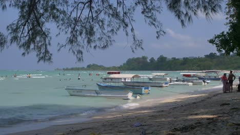 Los-Turistas-Indios-Vadeando-En-Aguas-Poco-Profundas-Entre-Los-Barcos-De-Pesca-Y-Buceo-En-Una-Playa-En-La-Cadena-De-Islas-Andaman,-Cerca-De-Port-Blair.