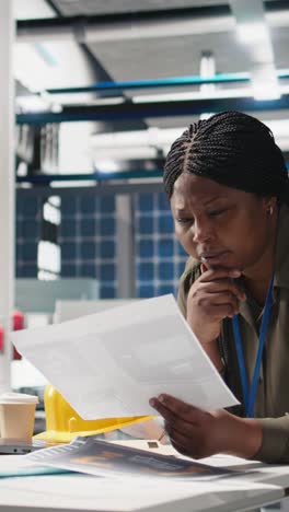 vertical video african american industrial inspector in solar energy reviews data on papers