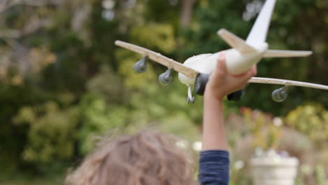 little boy playing with toy airplane happy child playing game imagining travel freedom having fun outdoors in sunny park enjoying childhood 4k