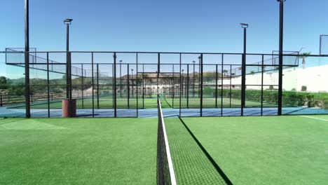 Reveladora-Foto-Rodante-A-Lo-Largo-De-La-Red-De-Una-Cancha-De-Pádel-Con-Impresionantes-Canchas-Nuevas-En-Exhibición