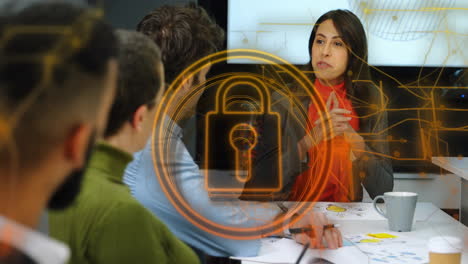 animation of padlock in circle over diverse woman sharing ideas with coworkers in office