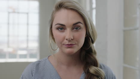 portrait-of-young-blonde-woman-looking-serious-intense-at-camera-in-apartment-home-background