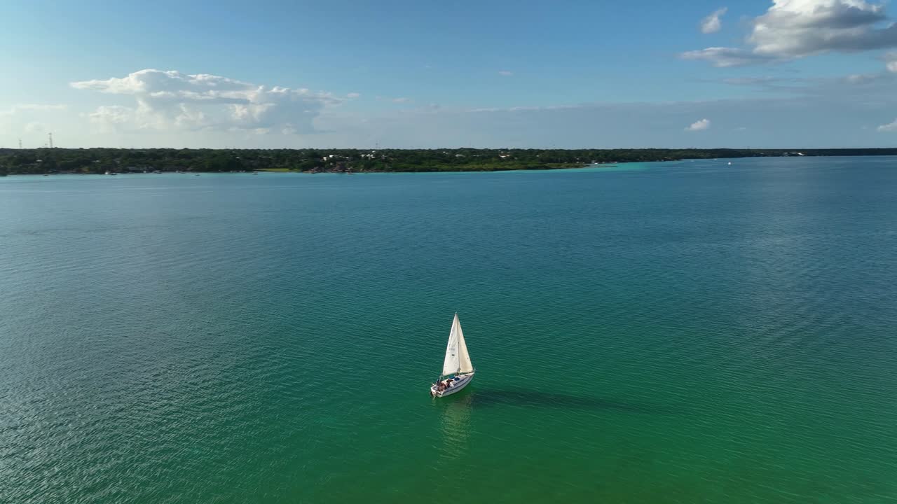 vista aérea alrededor de un barco de vela en la laguna bacalar, soleada quintana roo, méxico - órbita, disparo de drones