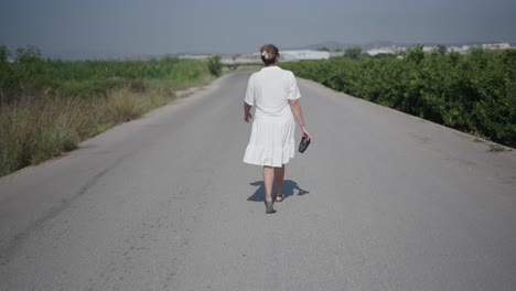 mujer caminando por un camino de campo