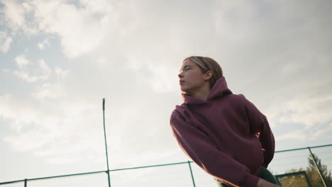 volley ball player jumps and slams ball over net on outdoor court under sunny skies with bar net in the background, action shot of athletic woman performing sports move outdoors