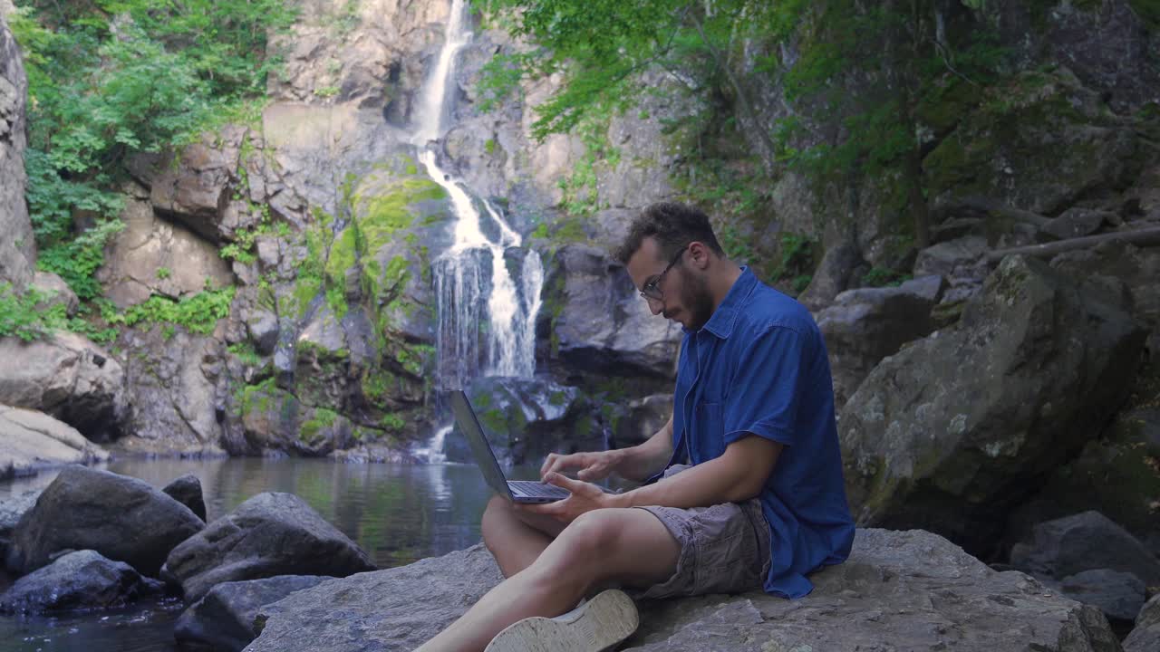 Lavorare con il computer portatile in una valle rocciosa