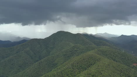 flying through the stormy day above green mountain tops. 4k aerial view of the rainforest