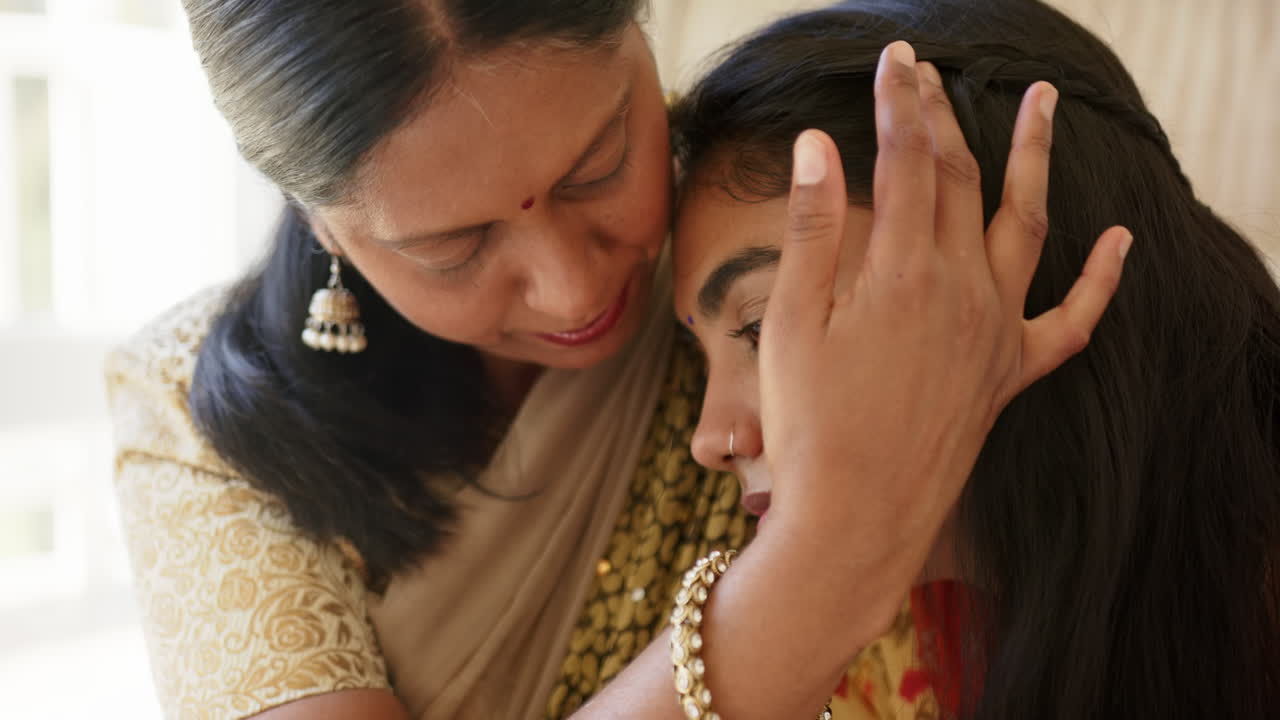 Mother comforting daughter, embracing her with love and care at home