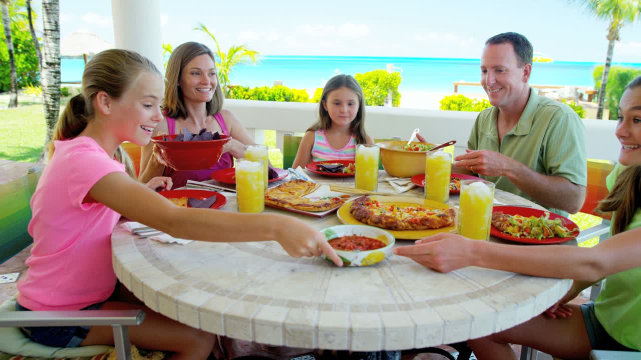 카우카스족 가족 이 해변 휴양지 에서 야외 에서 식사 하고 있다