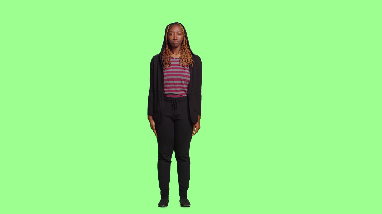 Woman standing and saluting on green screen