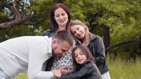 a pregnant family portrait in a park