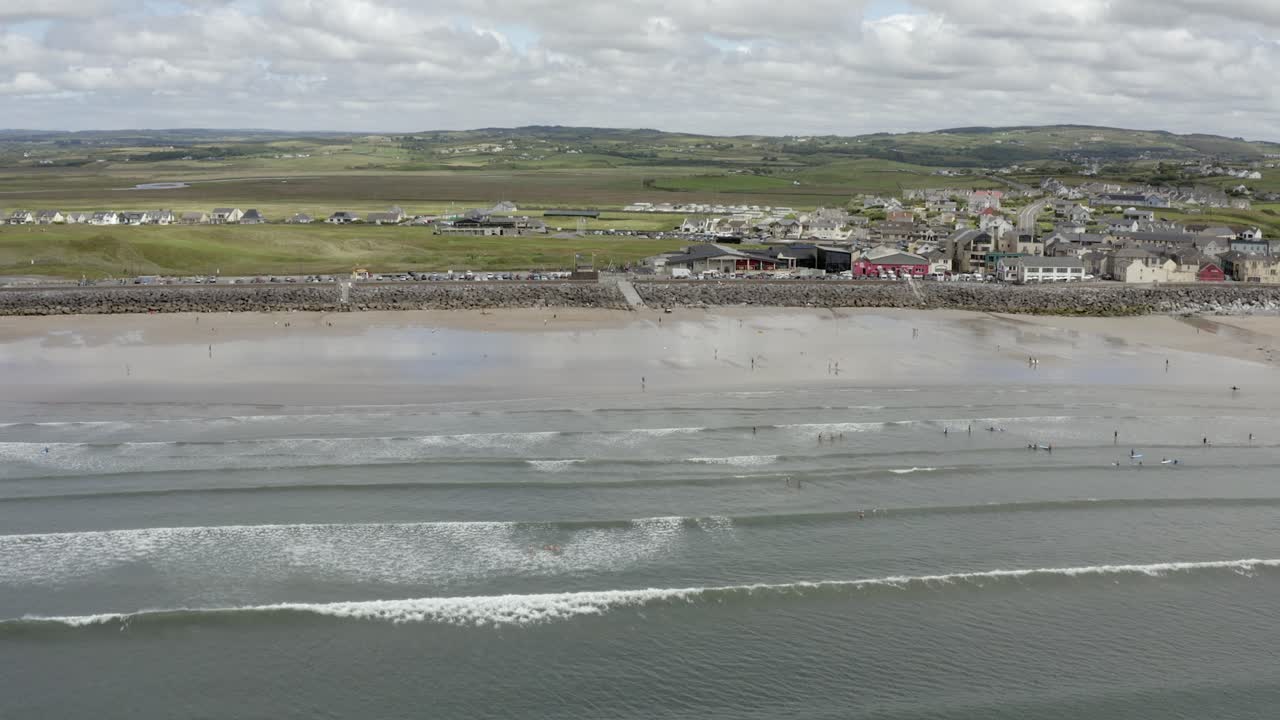 dolly aéreo a lo largo de la extensa playa de surf de arena en lahinch, irlanda