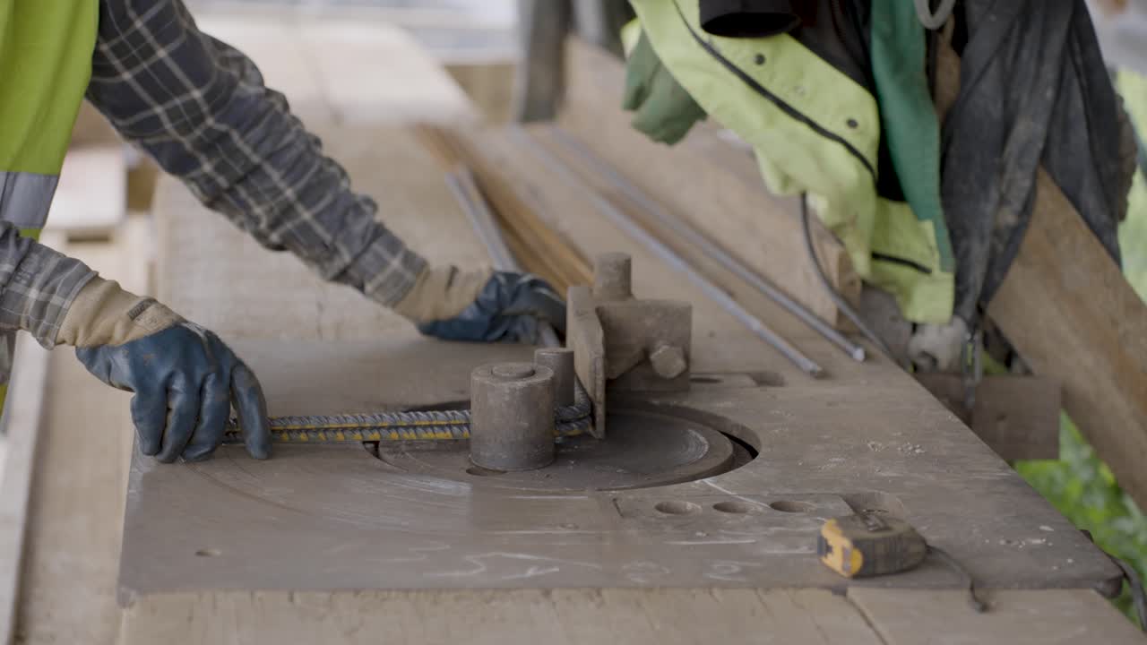 A construction worker bends steel rebar by hand on a building site, showing skill and precision in preparing reinforced steel for concrete.Perfect for documentaries, education, and construction videos