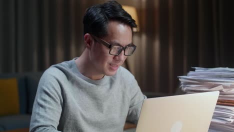 집 에서 문서 를 작업 하는 동안 노트북 컴퓨터 를 입력 하는 아시아인 의 근접 사진