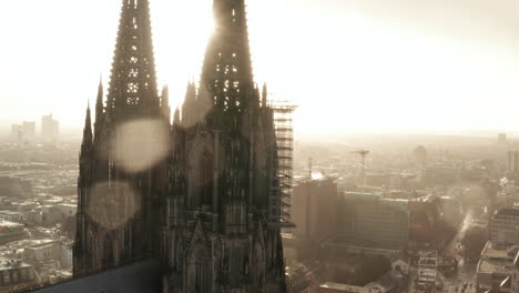 Close-up-of-gothic-decorated-tower-of-church,-scaffolding-for-maintenance-or-repair-high-above-ground.-Fly-around-Cologne-Cathedral--Cologne,-Germany