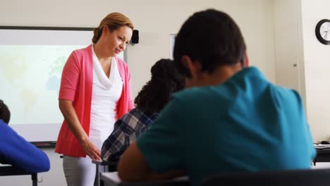 maestro ayudando a los estudiantes con sus tareas en el aula