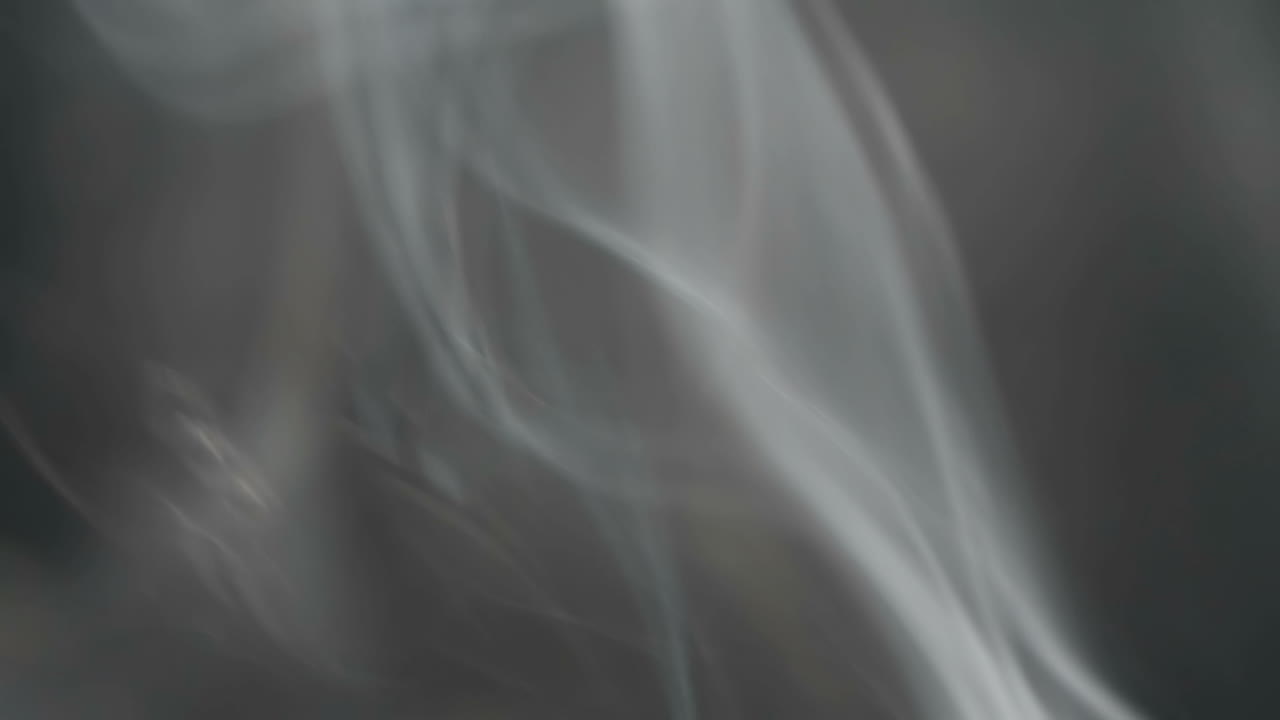 Slow motion. Smoke from fire. Puffs on a black background