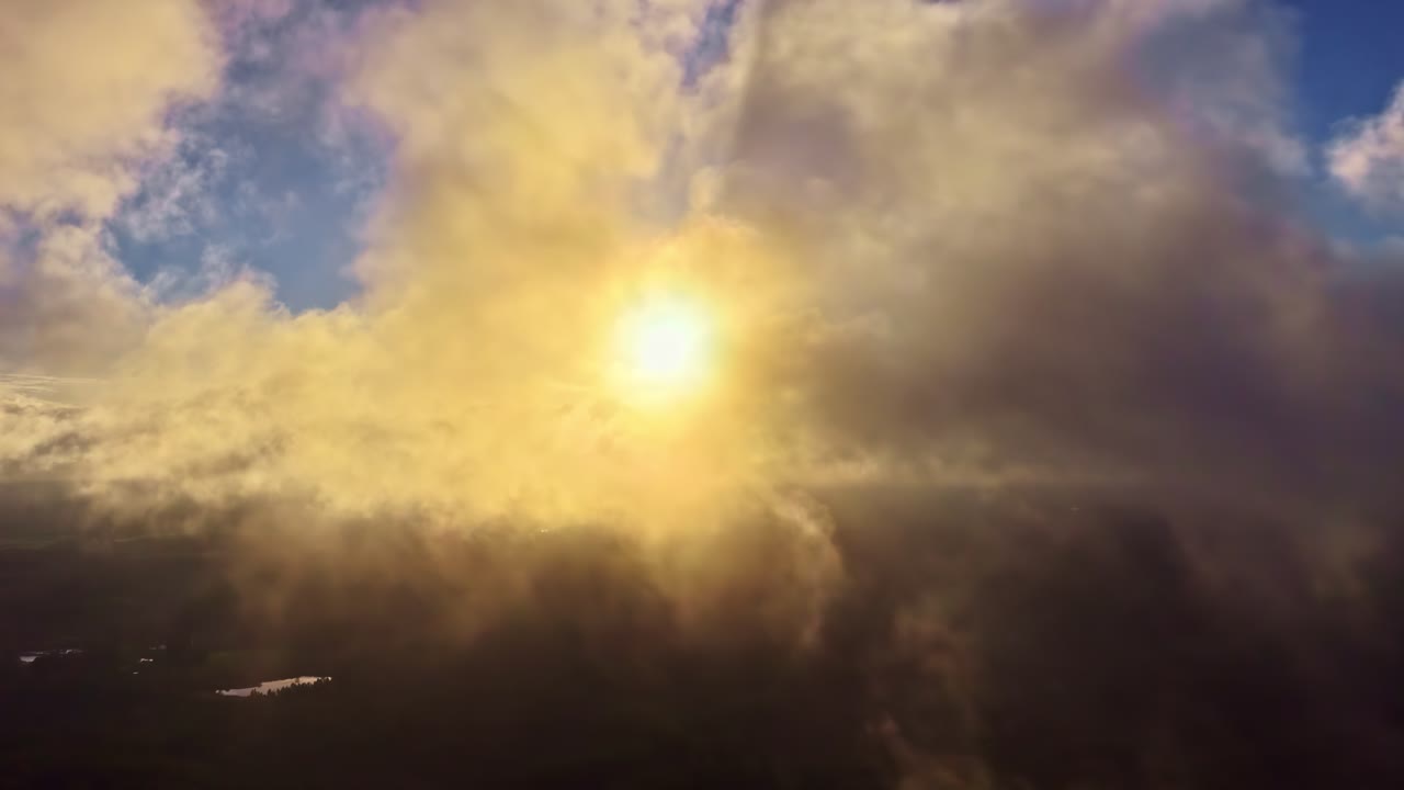 Raggi di sole cinematografici tra le nuvole, tramonto aereo sulla foresta, ora d'oro