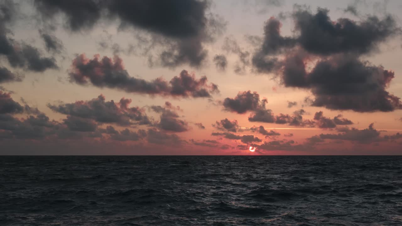 Zeitraffer eines Sonnenuntergangs auf Meeresspiegelhöhe bei teilweise bewölktem Himmel