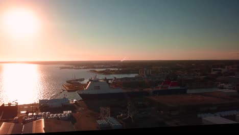 Beautiful-sunset-footage-of-a-small-harbor-with-a-large-ferry-and-a-tall-boat