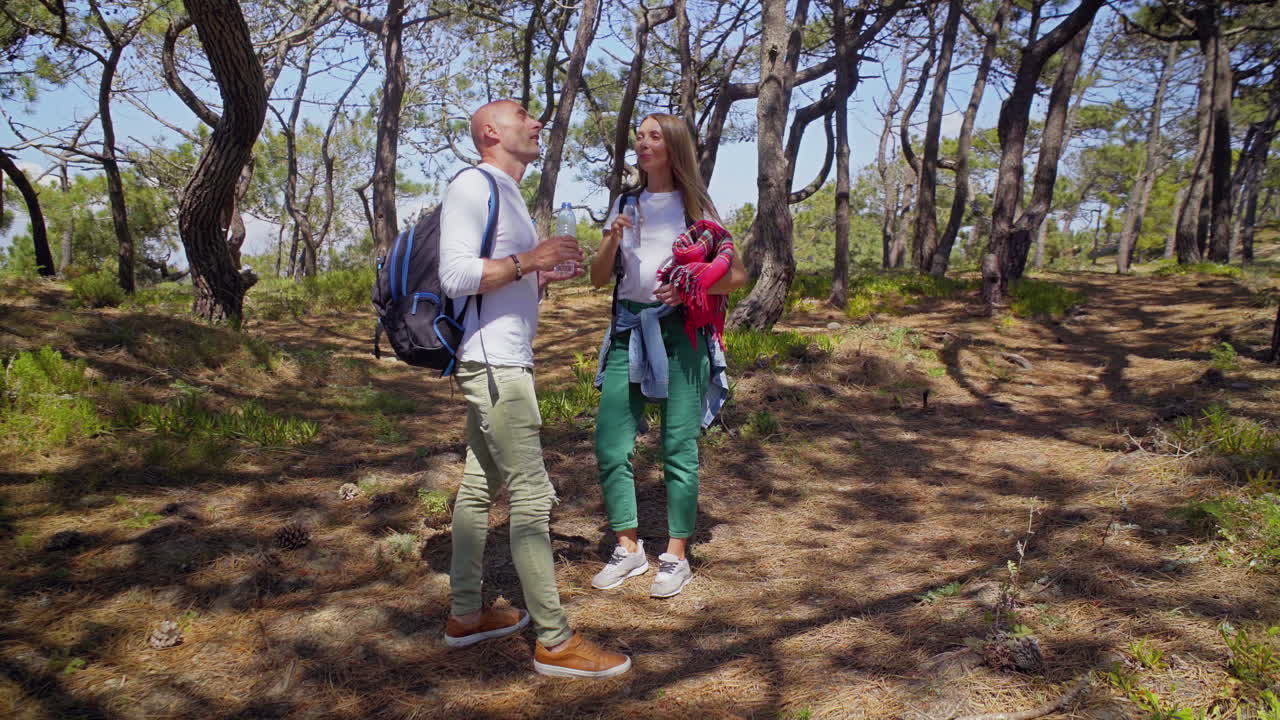 pareja de mochileros bebiendo agua al aire libre
