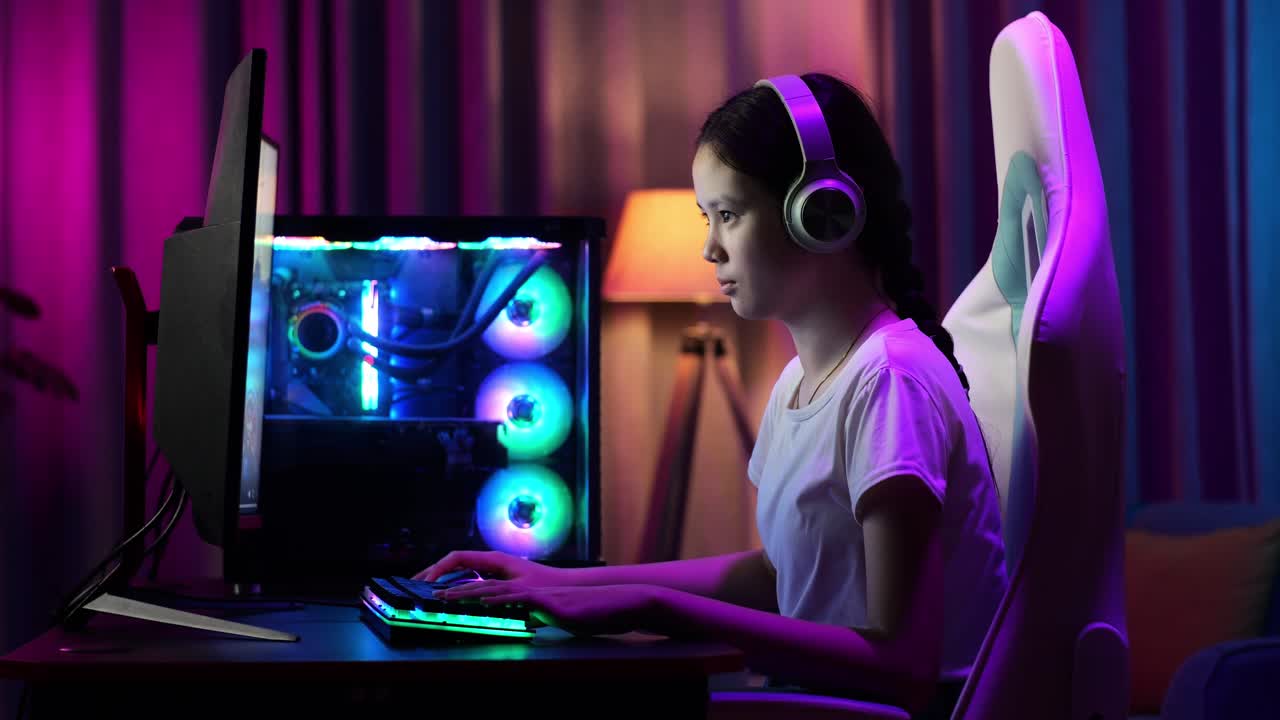 Ragazza gamer asiatica adolescente entusiasta che gioca a un videogioco al computer.
