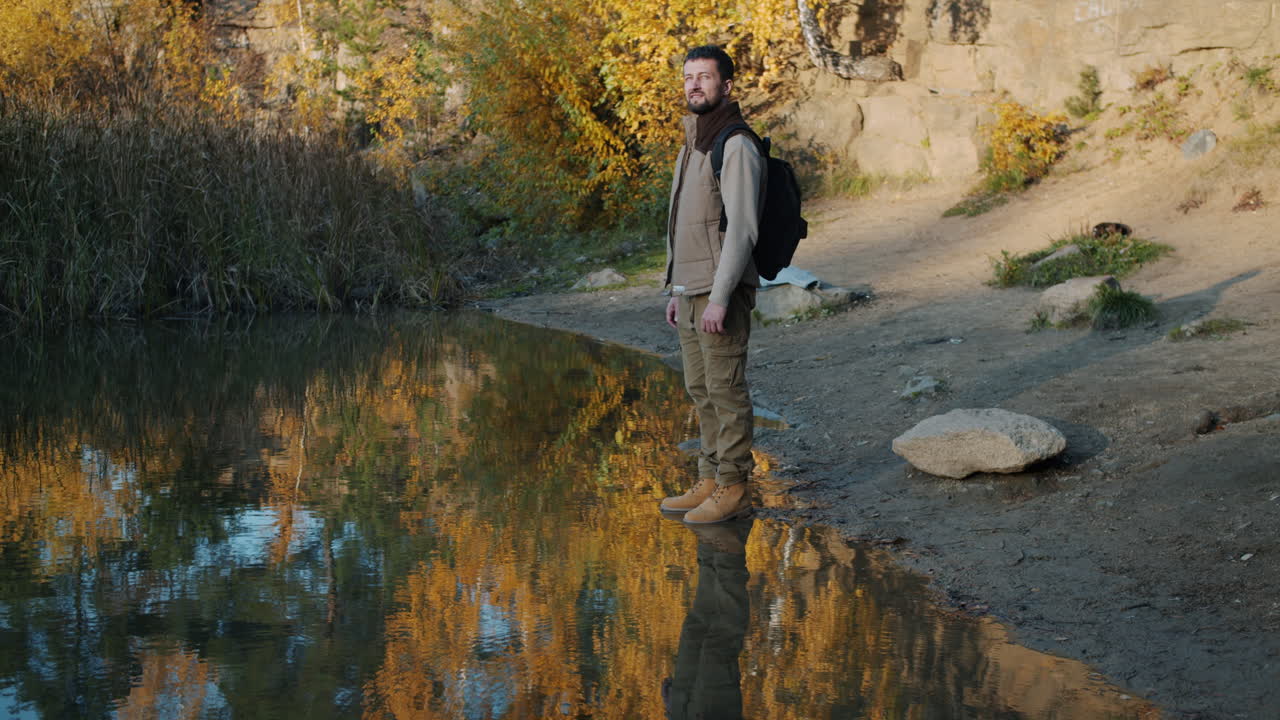 Man Hiking by a Calm Autumn Lake