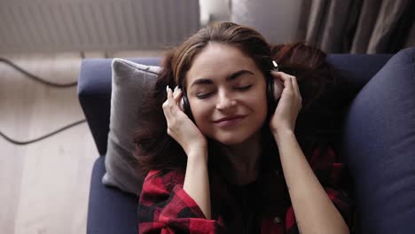 Young-attractive-brunette-girl-enjoys-listening-to-music.