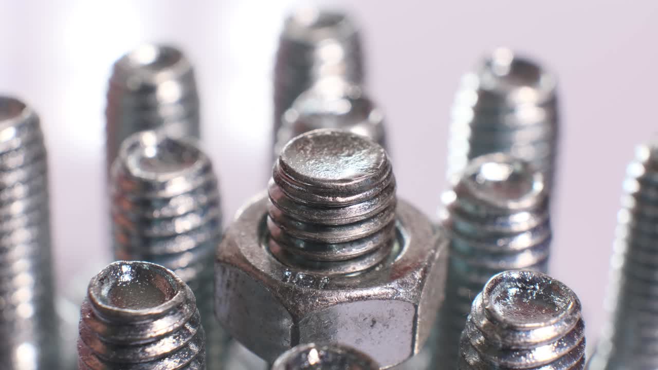 grupo giratorio de tornillos metálicos galvanizados de primer plano. pernos de acero inoxidable aislados sobre un fondo blanco.